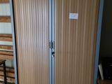 a wooden cabinet with a metal door in a room