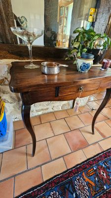 une table en bois sur laquelle est posé un verre de vin