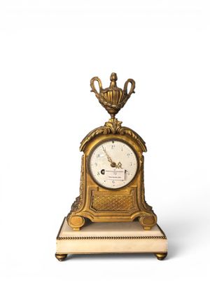 a gold clock with a crown on top of it