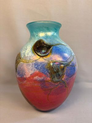 a colorful vase sitting on a white surface