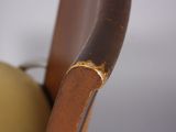 a close up of a brown chair with a gold ring on it