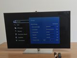 a flat screen tv sitting on a table with remote controls