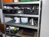 a metal shelf with various items on it in a kitchen