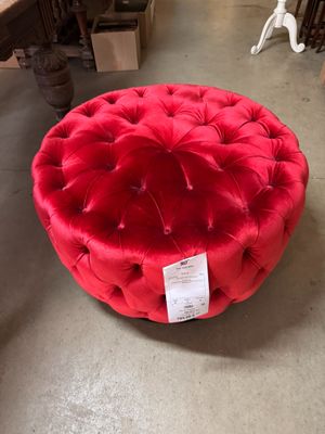 un pouf rond rouge posé à même le sol dans un magasin