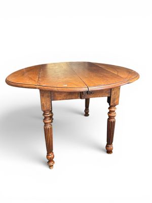 une table à manger ovale en chêne avec des pieds tournés