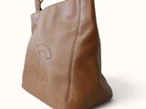 a close up of a brown handbag on a white background