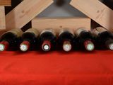 bottles of wine are lined up on a red table cloth