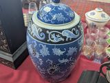 a blue and white vase sitting on a table next to a clock
