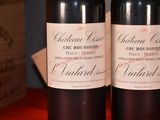 two bottles of wine sitting on a table next to each other