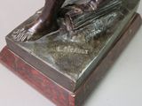 a bronze statue of a man sitting on a book