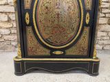 a black and gold cabinet with a clock on top of it