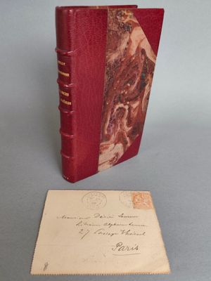 un vieux livre posé sur une table à côté d'une feuille de papier