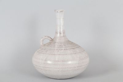a white vase with a handle sitting on a table
