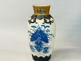 un vase bleu et blanc posé sur une surface blanche
