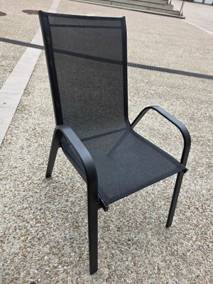 une chaise noire posée au milieu de la rue