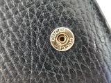 a close up of a black purse with a gold button