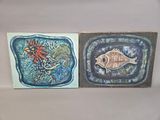 two paintings of a fish and a flower on the wall