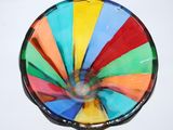 a multicolored glass bowl sitting on a white surface