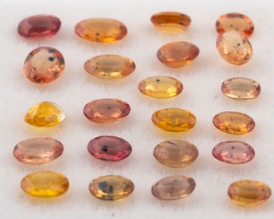 un assortiment de pierres précieuses de différentes couleurs posées sur une surface blanche