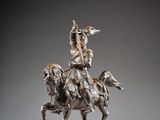 statue of a man riding a horse with a spear on its back