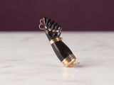 black and gold hand charm on a marble counter top