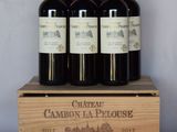 four bottles of wine are in a wooden box on a table