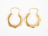 une paire de boucles d'oreilles en or sur fond blanc