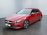 une Mercedes CLA rouge garée dans une pièce blanche