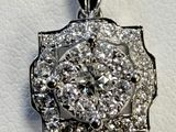 a close up of a diamond pendant on a white surface