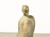 statue of a woman sitting on top of a wooden table