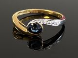 an image of a gold ring with a blue stone and diamonds