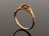 a close up of a gold ring with two hands holding each other
