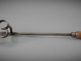 a large metal spoon with a wooden handle on a table