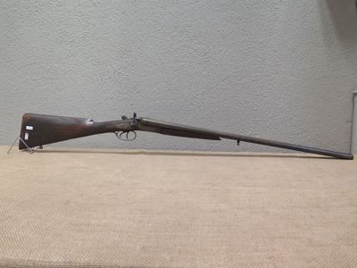 an old rifle sitting on top of a table next to a wall