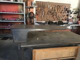 une photo d'un établi dans un atelier, avec des outils accrochés au mur