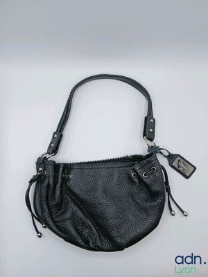 a black purse with a zipper on the side and a tag attached to it