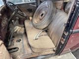 an old car with a steering wheel in the back