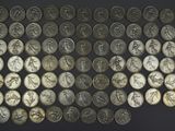 a close up of a bunch of silver coins on a black surface