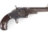 un vieux revolver avec un manche en bois sur fond blanc