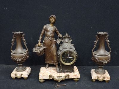 trois vases en bronze et une horloge posés sur une table