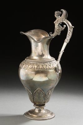 an image of a silver vase with a handle on a table