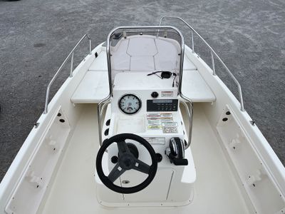 a white boat with a steering wheel and a clock on it