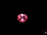 a close up of a pink diamond on a black surface