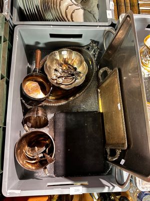 un récipient en métal rempli d'assiettes et de bols posé sur une table