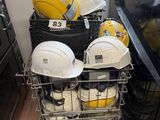un panier rempli de casques de chantier et d'autres équipements de sécurité