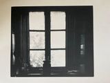 a black and white photo of a cat sitting on a couch