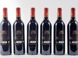 six bottles of red wine lined up in a row on a white surface