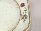 two plates with flowers on them on a white table