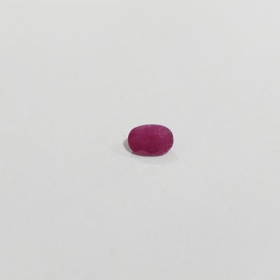 a single pink stone sitting on top of a white surface