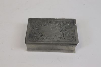 une vieille boîte en argent posée sur une table blanche
